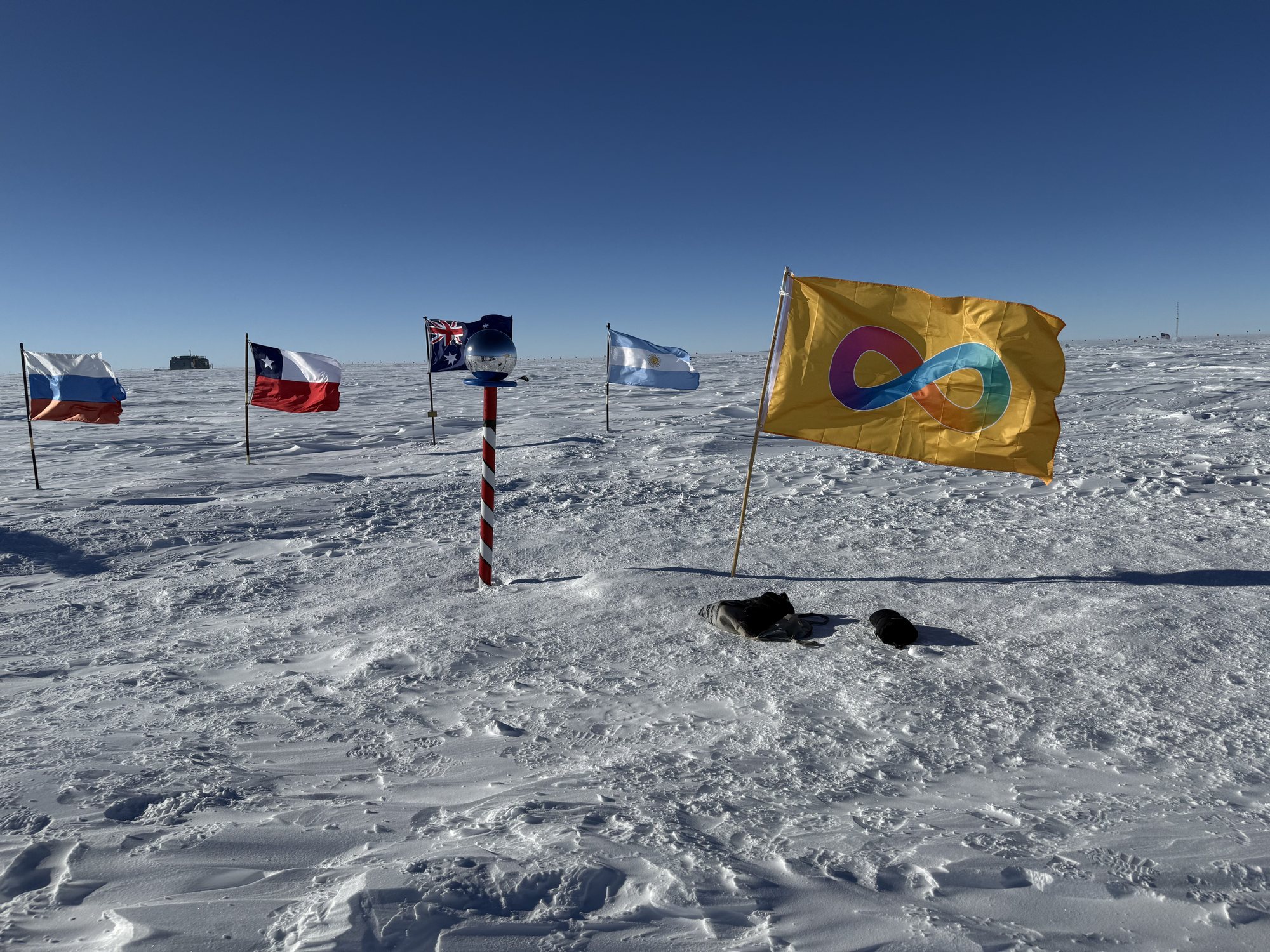 The Autistic Pride flag flying alongside flags at the South Pole.