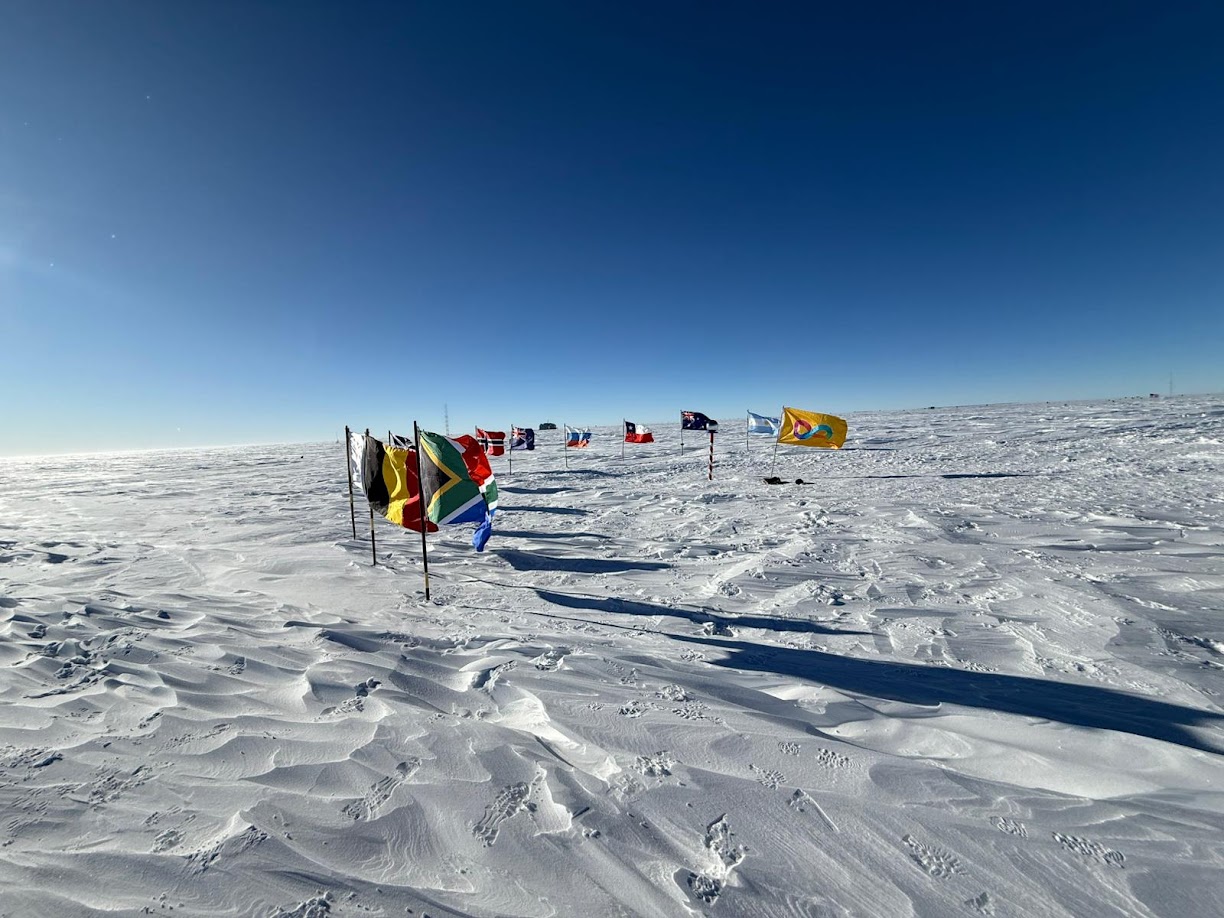 The Autistic Pride flag flying alongside flags at the South Pole.